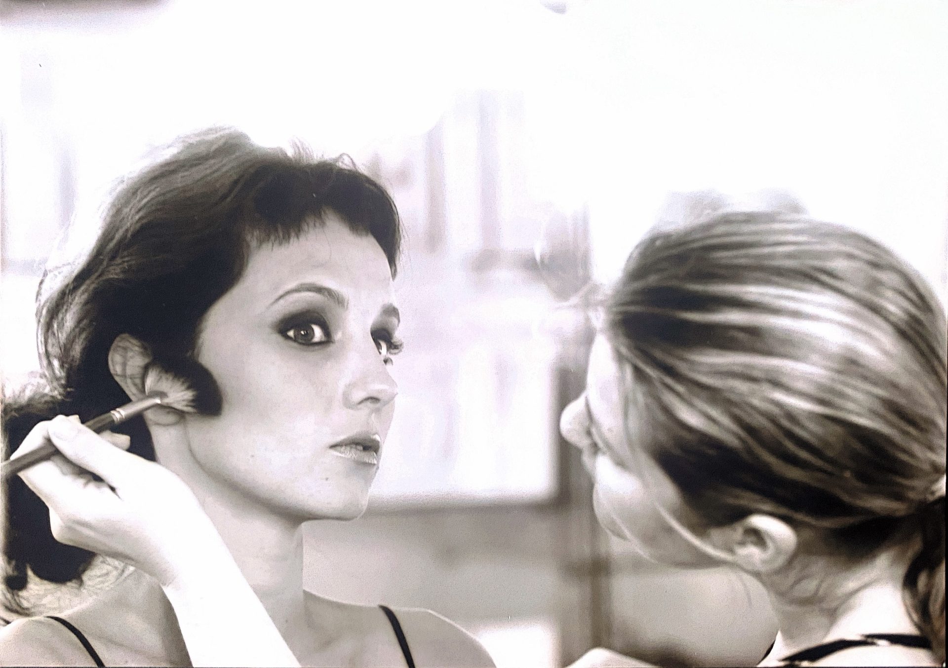 Florence Didero maquillant un modèle au pinceau, photographie en noir et blanc
